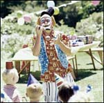 Un clown entouré d’enfants lors d’un camp de vacances en plein air