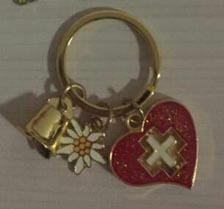 Porte-clés souvenir avec un cœur rouge à croix suisse, une edelweiss et une vache